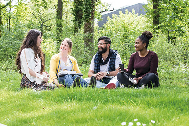 Kent Business School: Students sit and chat on campus grounds